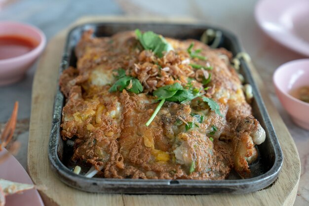 Tortilla de ostras frescas en la placa caliente negra lista para comer