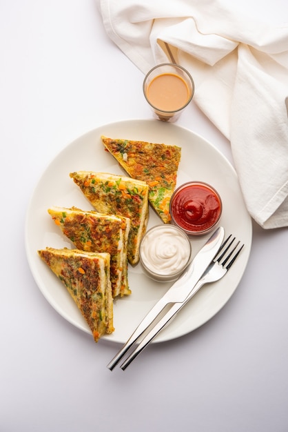 Tortilla de pan es un desayuno rápido y fácil de la India. Rebanadas de pan fresco bañadas en masa de huevo con especias y poco fritas. servido con salsa de tomate y té