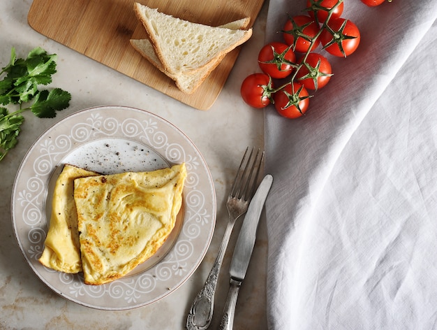 Tortilla en un plato, perejil, tomates, tostadas