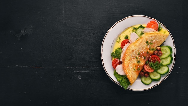 Tortilla con pollo y verduras frescas y nueces Sobre un fondo de madera Vista superior Espacio de copia