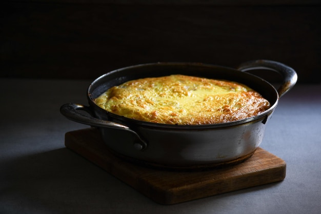 Tortilla rústica con patatas en una cacerola de metal sobre la mesa de la cocina