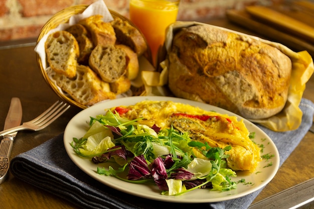 Tortilla de verduras y lechuga, pan y zumo de naranja, desayuno