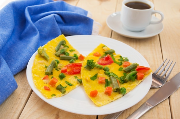 Foto tortilla de verduras sobre un fondo de madera y una taza de café. desayuno.