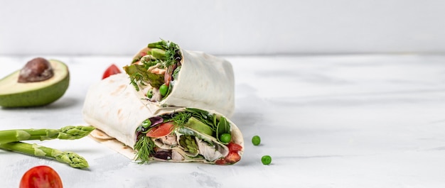 Tortilla-Wrap mit gebratenem Hühnerfleisch und Spargel, Avocado, Tomaten, Erbsen, Käse und Tatar