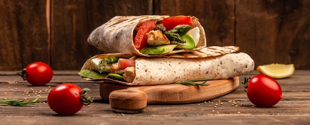 Tortilla-Wrap mit Spargel-Kirsch-Tomaten-Avocado-Hähnchenfilet und frischem Salat gesundes Essen Draufsicht Langes Banner-Format Platz für Text