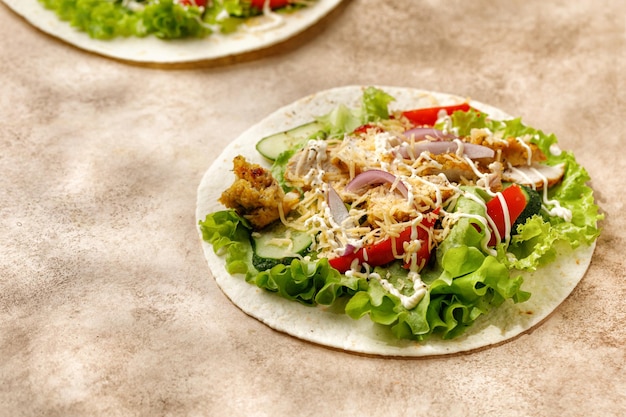 Tortillas Flatbread com sanduíche de molho de queijo de alface de carne de frango em fundo bege