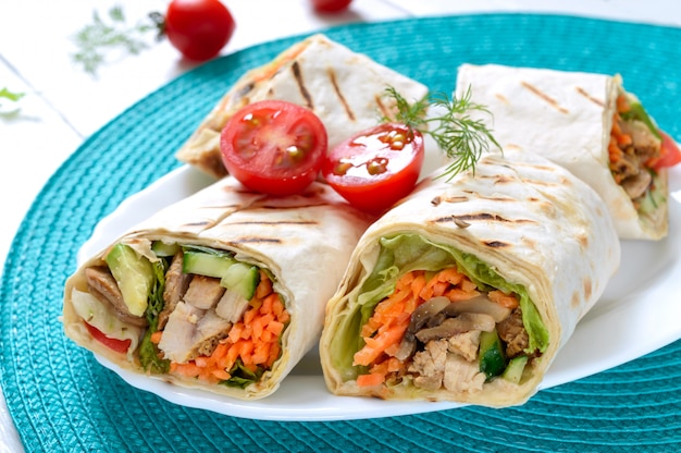 Tortillas frescas envueltas con pollo, champiñones y verduras frescas. Burrito de pollo a la mexicana. Sabroso aperitivo Platos de pan de pita. Concepto de comida sana