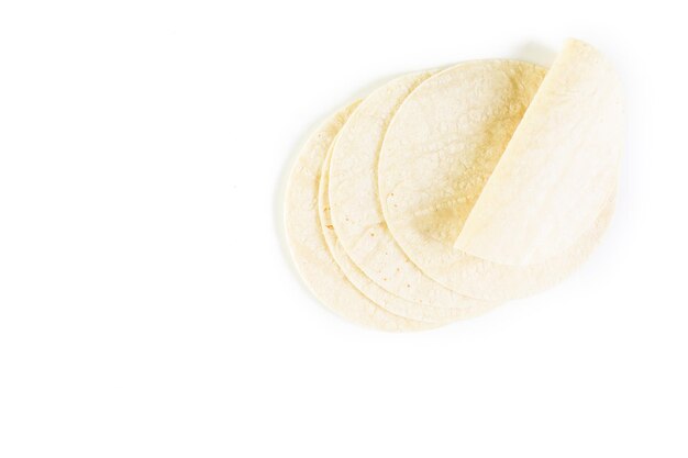 Tortillas de maíz blanco fresco sobre un fondo blanco.