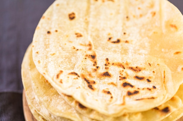 Tortillas de maíz blanco fresco en la tabla de cortar.