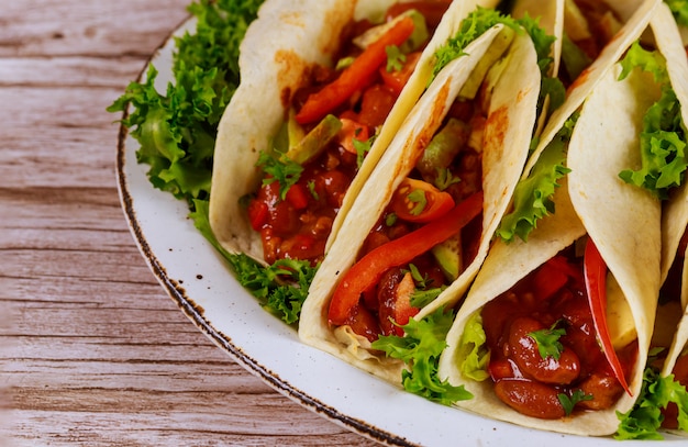 Foto tortillas suaves con frijoles con chile, carne y vegetales comida mexicana.