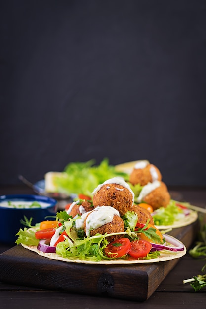 Tortillaverpackung mit Falafel und frischem Salat.