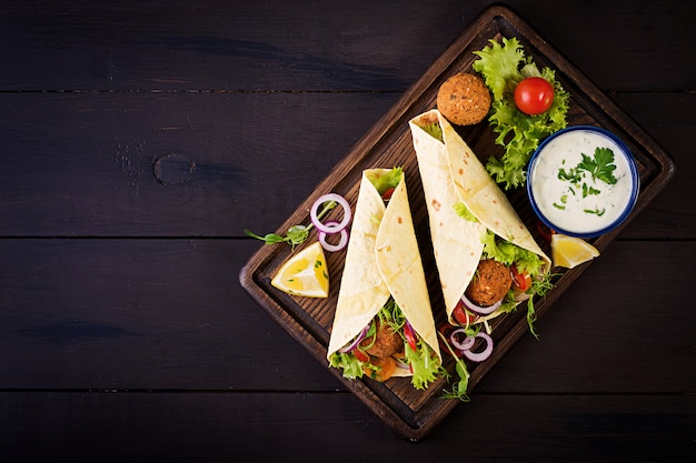 Tortillaverpackung mit Falafel und frischem Salat.