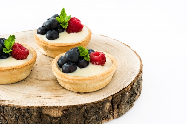 Tortinha deliciosa com framboesas e mirtilos isolados na mesa branca