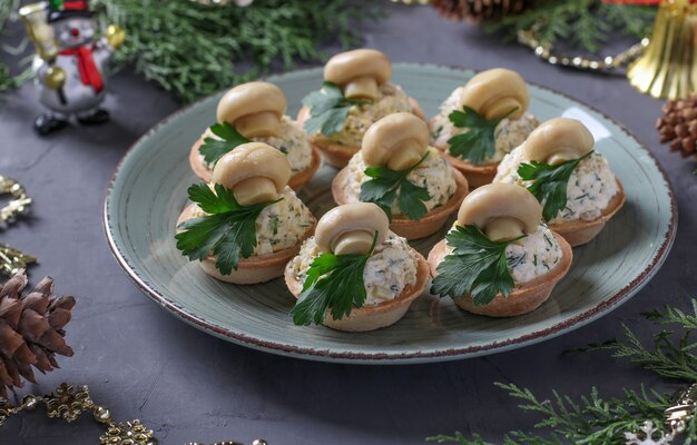 Tortinhas com cogumelos, ovo e queijo em um fundo cinza escuro. Lanche delicioso de férias.