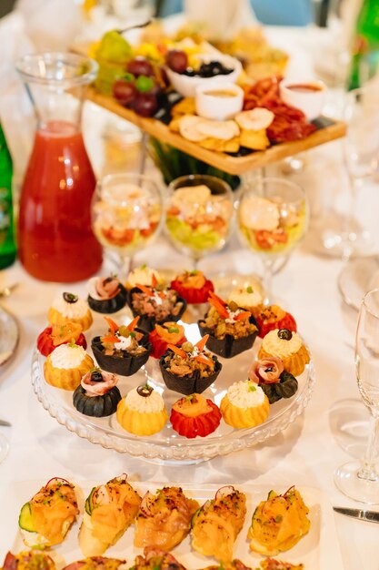 Foto tortinhas com saladas, lanches e bebidas, serviço conveniente de lanches para o buffet de catering para o feriado