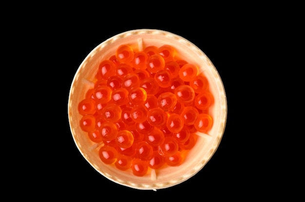 Foto tortinhas de caviar vermelho isoladas em um fundo preto. delicadeza no café da manhã.