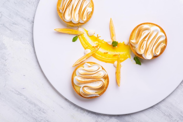 Tortinhas de limão apetitosas com merengue servidas em um prato branco