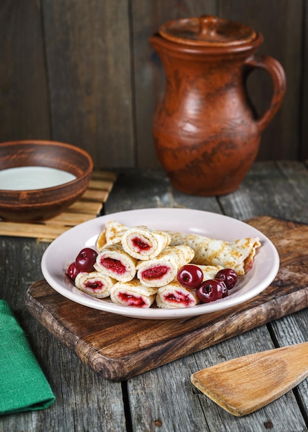 Tortitas caseras con cerezas en una mesa de madera de estilo rústico