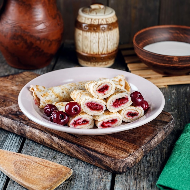 Tortitas caseras con cerezas en una mesa de madera de estilo rústico