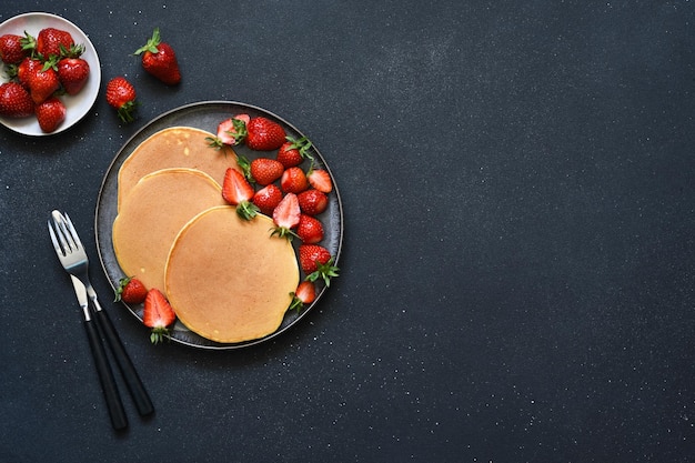 Foto tortitas caseras con fresas y arándanos para el desayuno postre americano