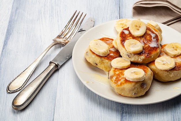 Tortitas caseras con pasas untadas con leche condensada y acompañadas de plátanos cortados