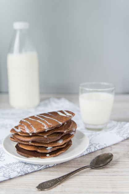 Tortitas de chocolate con el vaso y la botella de leche