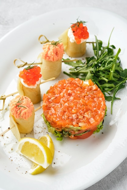 Tortitas delgadas, crepes con salmón y caviar rojo y tartar de pescado