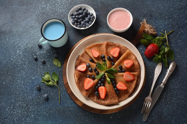 Tortitas dulces envueltas con arándanos frescos, fresas de menta