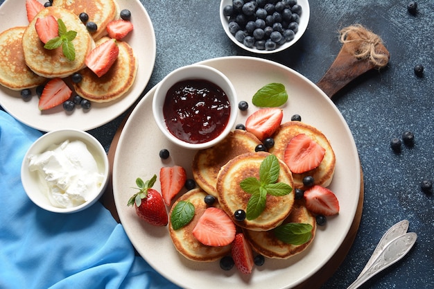 Tortitas dulces envueltas con arándanos frescos, fresas de menta