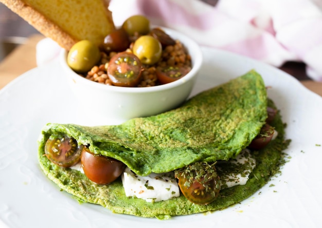 Tortitas de espinacas con queso y tomates cherry con ensalada de lentejas. Comida vegetariana lista para comer