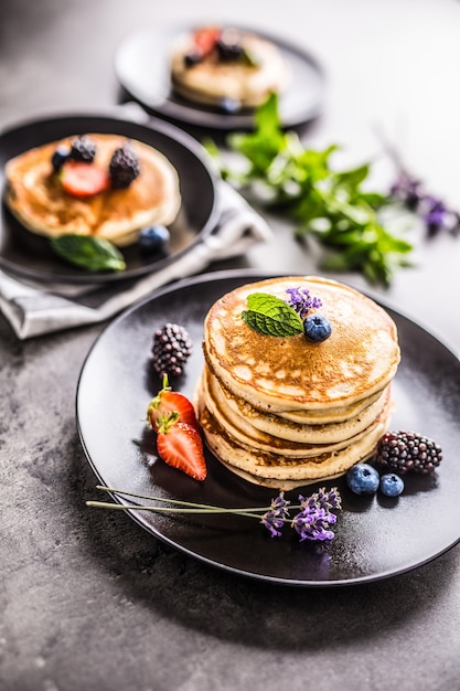 Tortitas con fresas, moras, arándanos, levadura y hojas de menta.