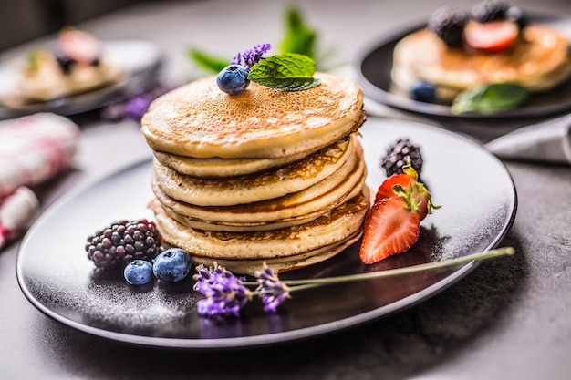 Tortitas con fresas, moras, arándanos, levadura y hojas de menta.