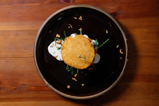 Tortitas de papa con champiñones y tocino en salsa de crema agria vista superior