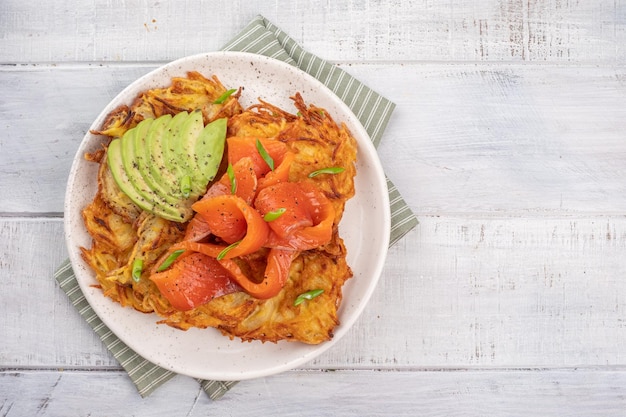 Tortitas de patata frita con salmón y crema agria buñuelos roesti corteza dorada crujiente Desayuno tradicional de comida deliciosa