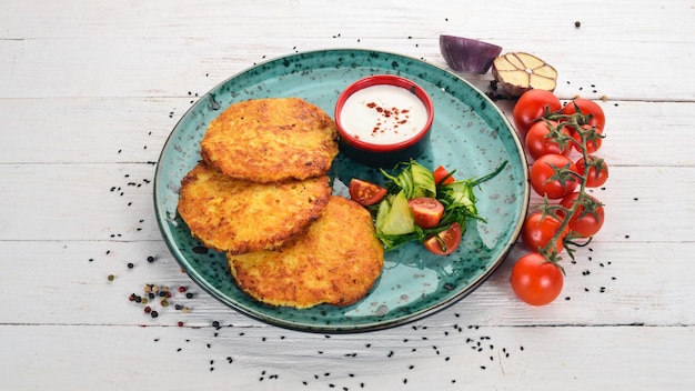 Tortitas con patatas con crema agria Tortitas de patata Cocina tradicional ucraniana En una mesa de madera Vista superior Espacio de copia