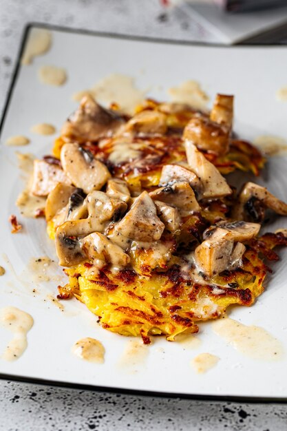 Tortitas de patatas fritas con champiñones guisados en un plato