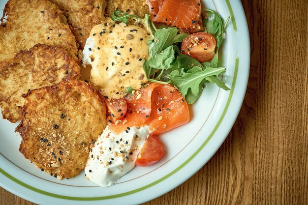 Tortitas de patatas fritas con huevo escalfado y salmón ligeramente salado. Hashbrown, dranik