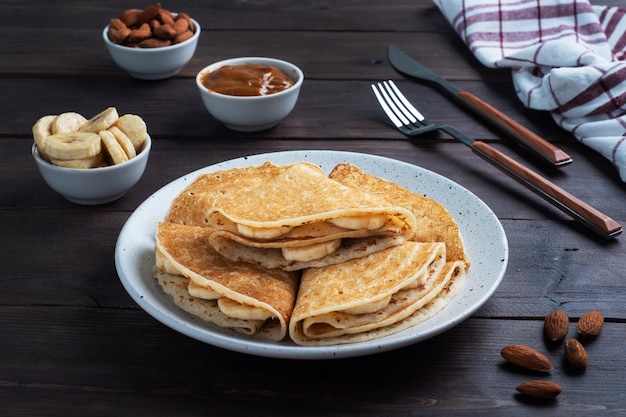 Tortitas con relleno de plátano y chocolate Mesa rústica de madera dulce postre delicioso