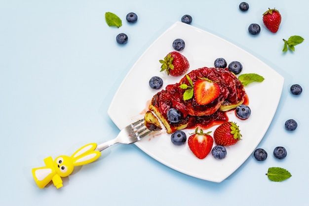 Tortitas de requesón con frutos rojos frescos y salsa de fresa para niños