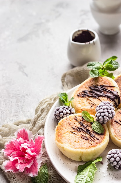 Tortitas de requesón con moras, chocolate y menta. Syrniki Desayuno Gourmet.