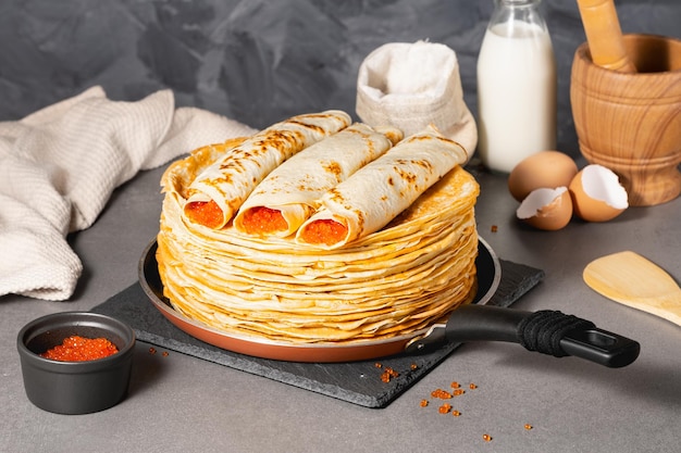 Tortitas rusas tradicionales con mantequilla y caviar rojo