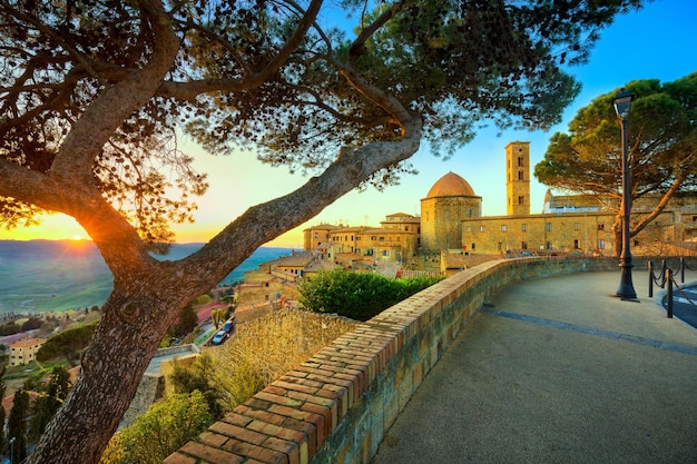 Toscana Volterra cidade horizonte igreja e árvores no pôr do sol Itália