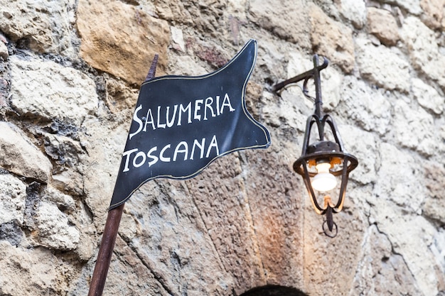 Toskana, Italien. Traditionelles Straßenschild der Metzgerei an einer alten Mauer