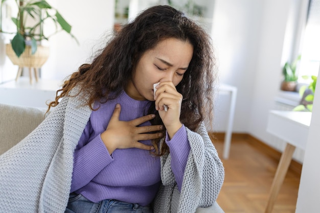 Tosse de gripe fria Mulher doente tossindo sentada no sofá em casa Mulher asiática doente com gripe deitada no sofá Coronavírus de gripe fria covid19