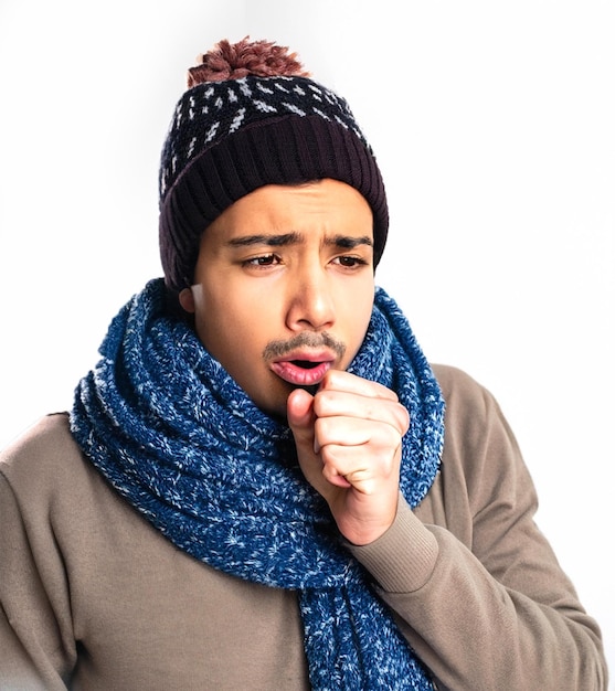 Tossindo jovem doente usando chapéu de inverno com cachecol colocando a mão na boca isolada