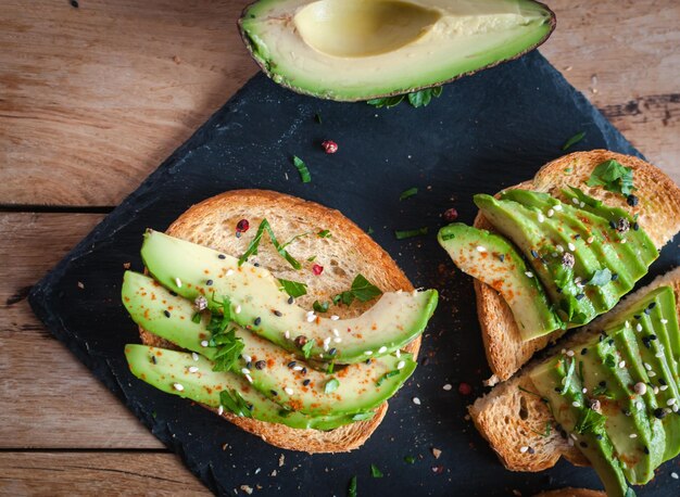 Foto tosta de aguacate fresco con especias en fondo oscuro vista de arriba