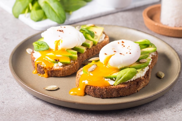 Tosta con aguacate, queso crema tierno, pan de centeno y huevo poché.