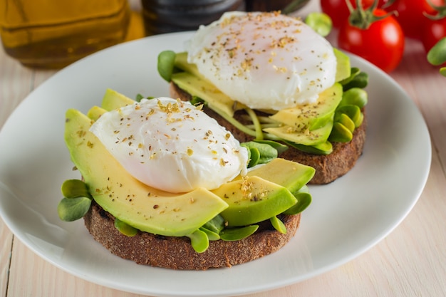 Tostada de aguacate con tomate cherry y huevos escalfados.