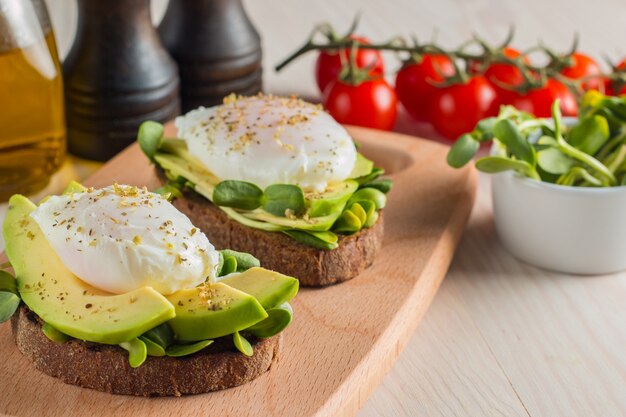 Tostada de aguacate con tomate cherry y huevos escalfados.