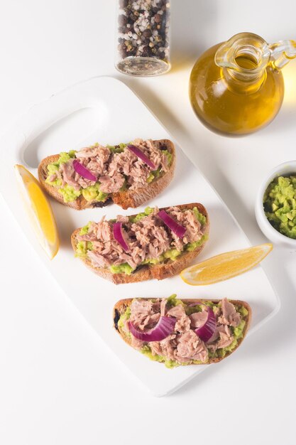 Tostada con Conservas de Atún Sándwich abierto con aguacate, cebolla morada y limón